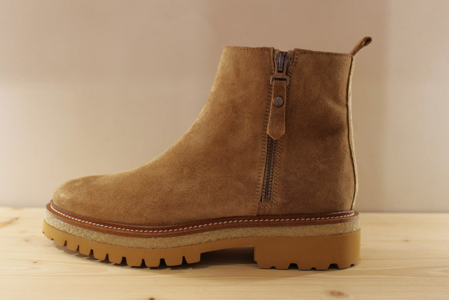 Bottines en croûte de cuir de couleur marron taupe. Serrage zip coté interne ton sur ton. Zip du côté externe décoratif.