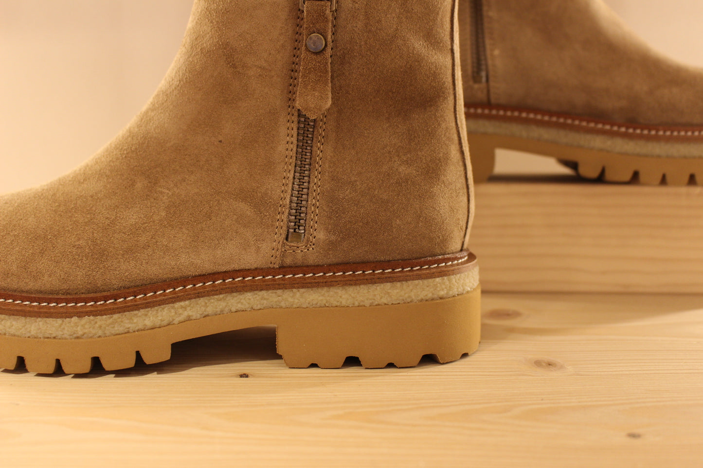 Bottines en croûte de cuir de couleur marron taupe. Serrage zip coté interne ton sur ton. Zip du côté externe décoratif.
