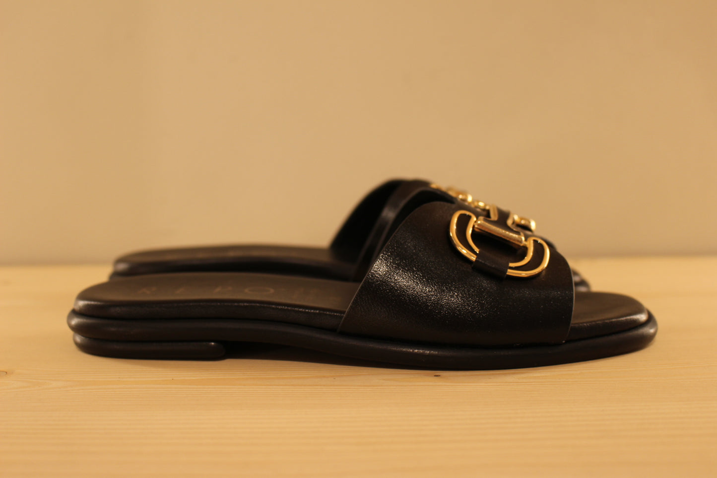 Mules en cuir de couleur noir. Habillage boucle noir et doré décoratif REPO
