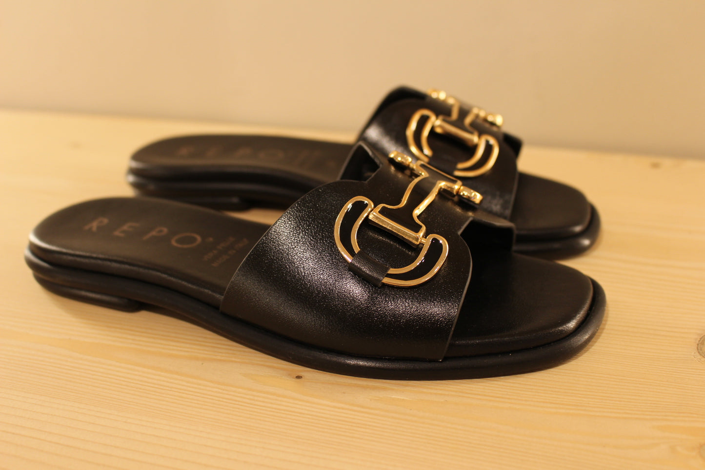 Mules en cuir de couleur noir. Habillage boucle noir et doré décoratif REPO