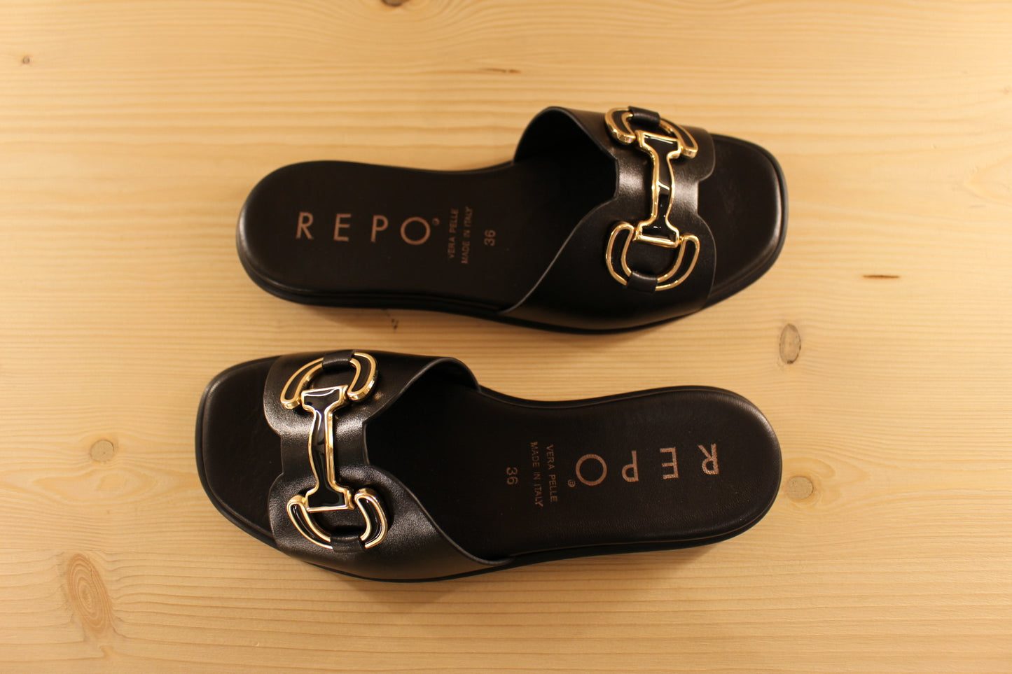 Mules en cuir de couleur noir. Habillage boucle noir et doré décoratif REPO