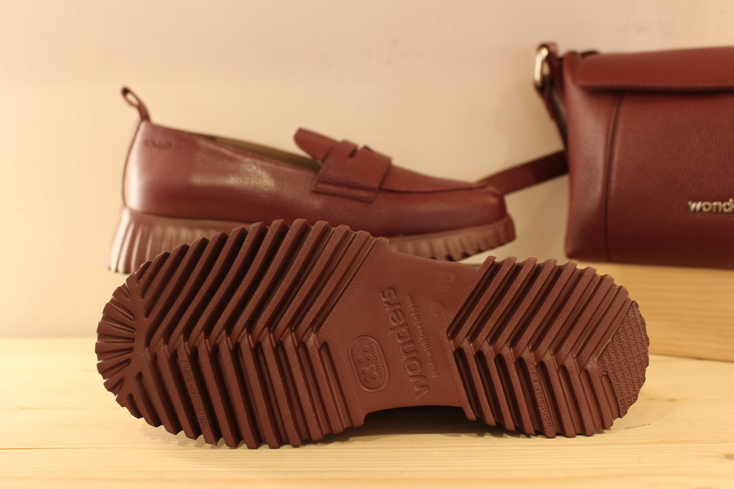 Mocassins WONDERS en cuir grainé de couleur bordeaux. Barette décorative ton sur ton. Chaussures doublées cuir et semelle interne amovible