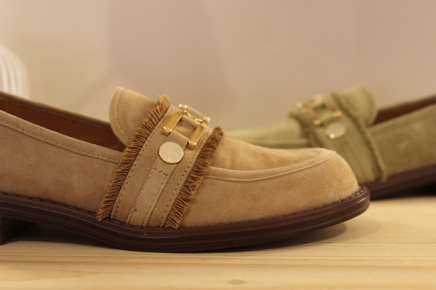 Mocassin en cuir velours de couleur sable ou de couleur kaki. Barette bijoux métallisés dorés et franges.