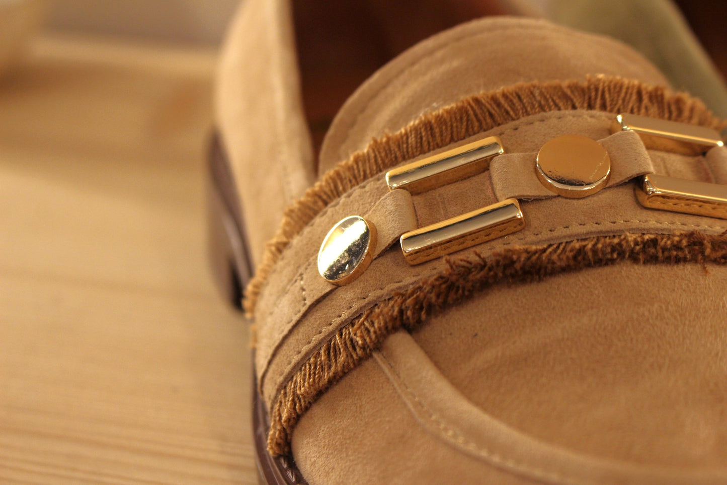 Mocassin en cuir velours de couleur sable ou de couleur kaki. Barette bijoux métallisés dorés et franges.