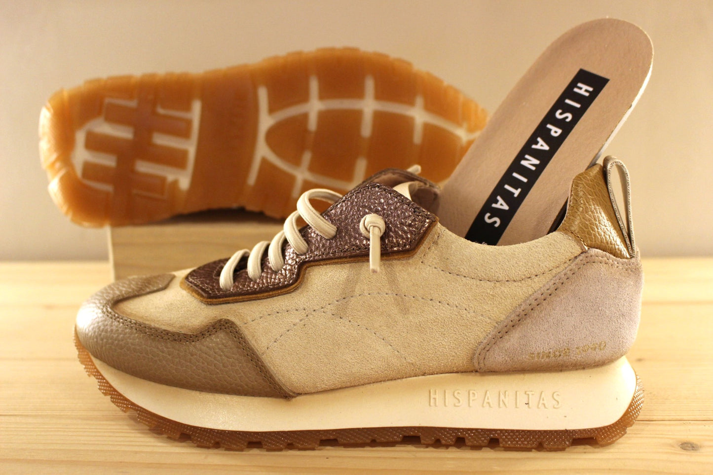 Basket en cuir de couleur crème et métallisé étain. Languette en laine bouclette ton sur ton. Lacets élastiqués beige.