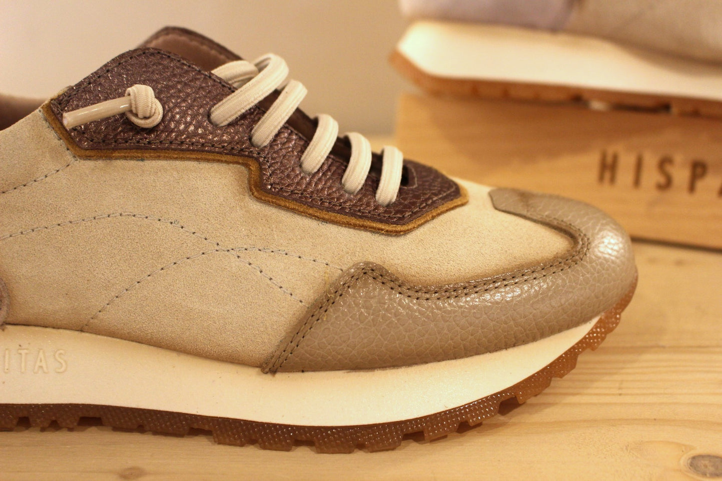 Basket en cuir de couleur crème et métallisé étain. Languette en laine bouclette ton sur ton. Lacets élastiqués beige.