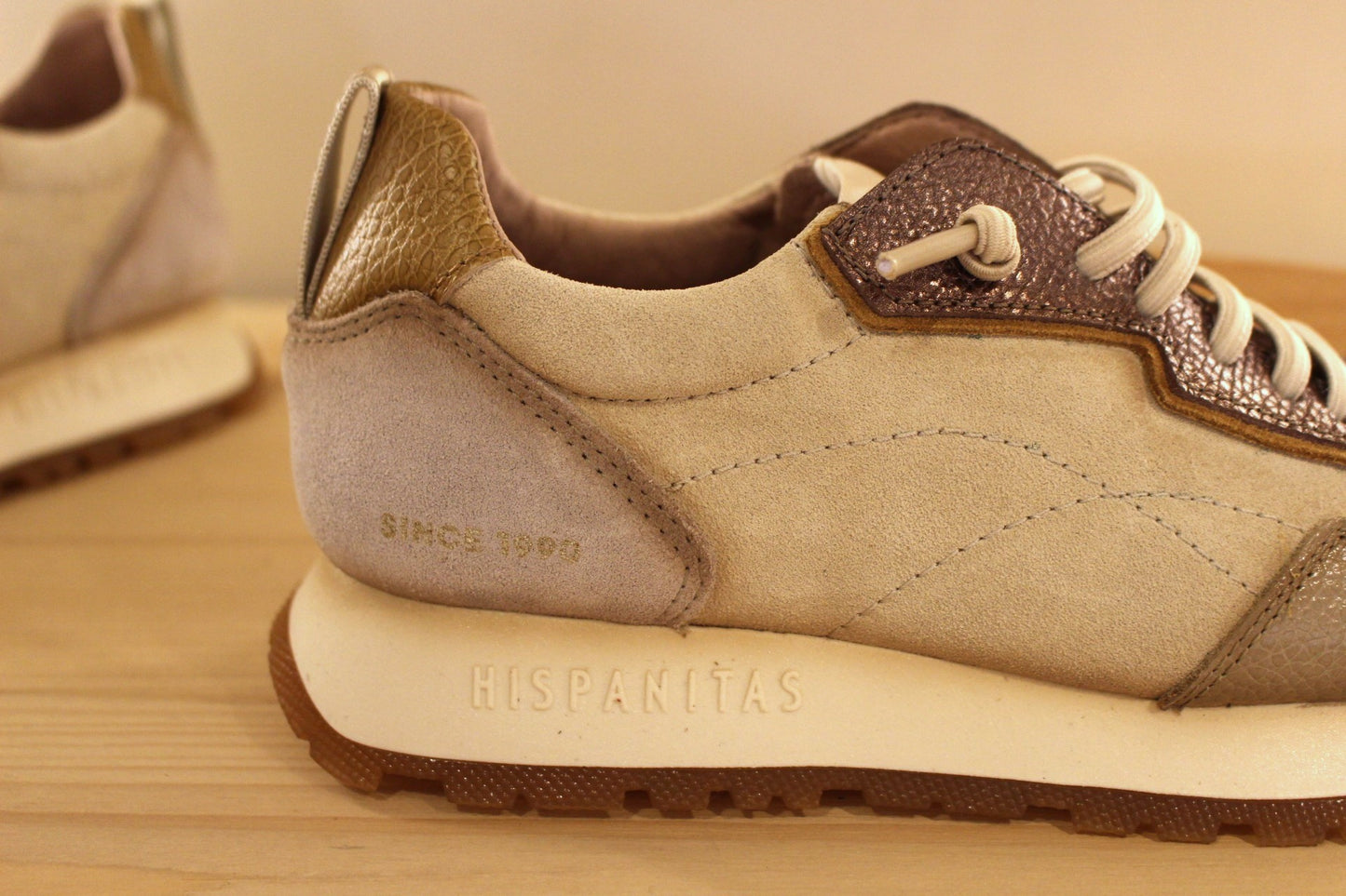 Basket en cuir de couleur crème et métallisé étain. Languette en laine bouclette ton sur ton. Lacets élastiqués beige.
