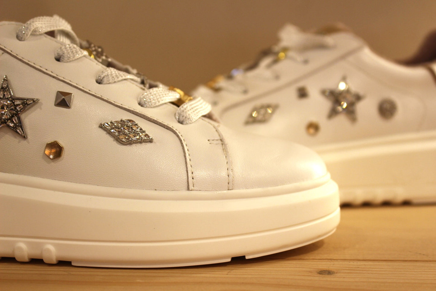 Sneaker MAMZELLE en cuir lisse de couleur blanche. Bijoux décoratifs sur le quartier externe et sur les lacets