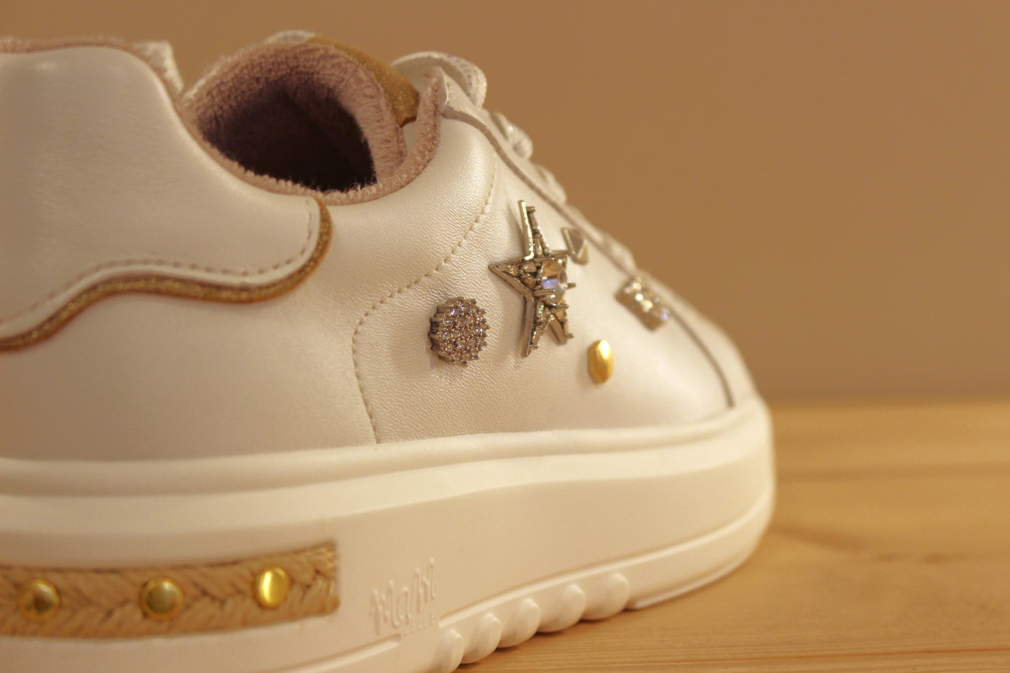 Sneaker MAMZELLE en cuir lisse de couleur blanche. Bijoux décoratifs sur le quartier externe et sur les lacets