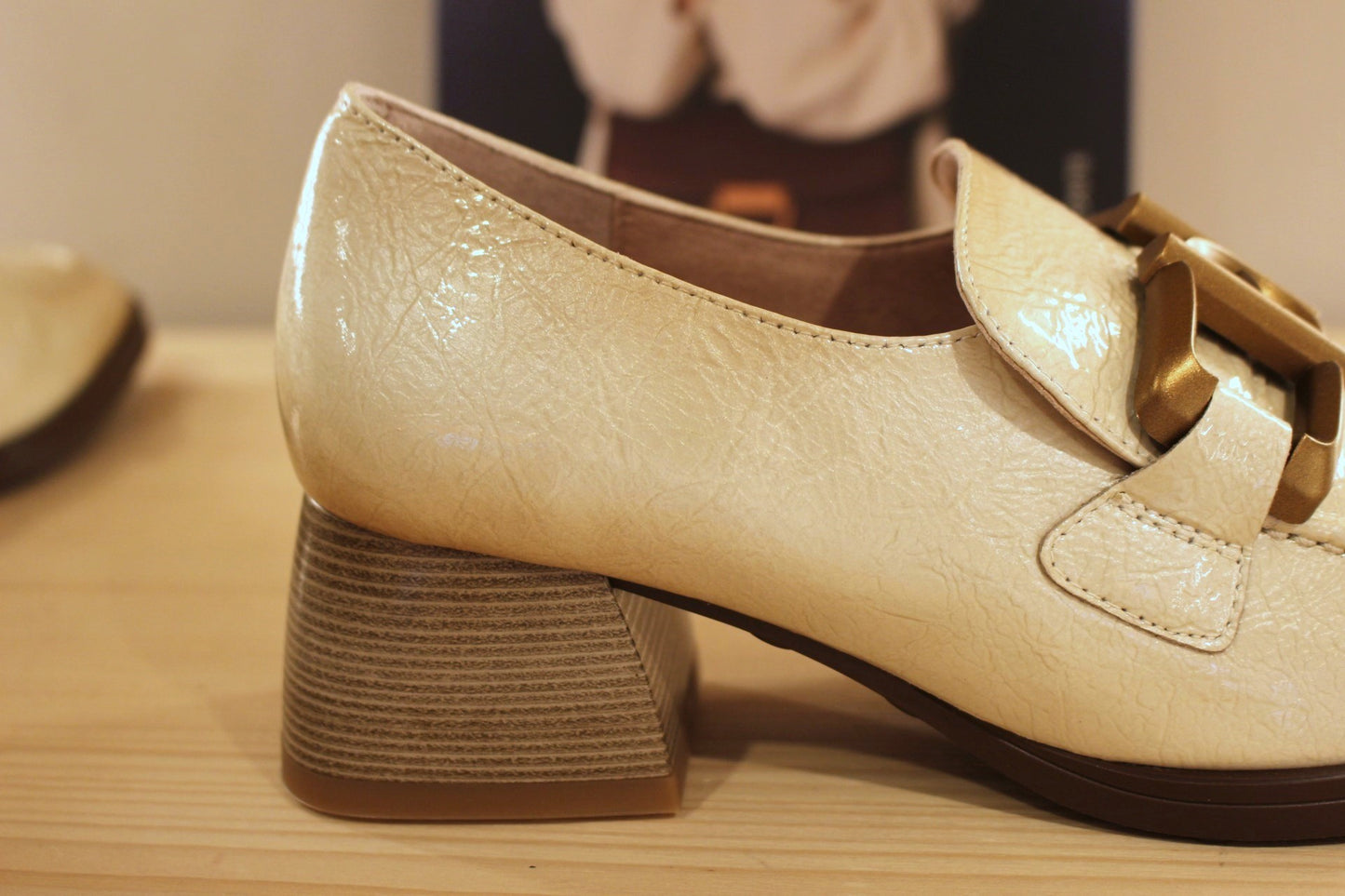 Mocassins en cuir vieillit, vernis de couleur crème avec une patine légèrement bruni. Boucle déco sur le coup de pied.