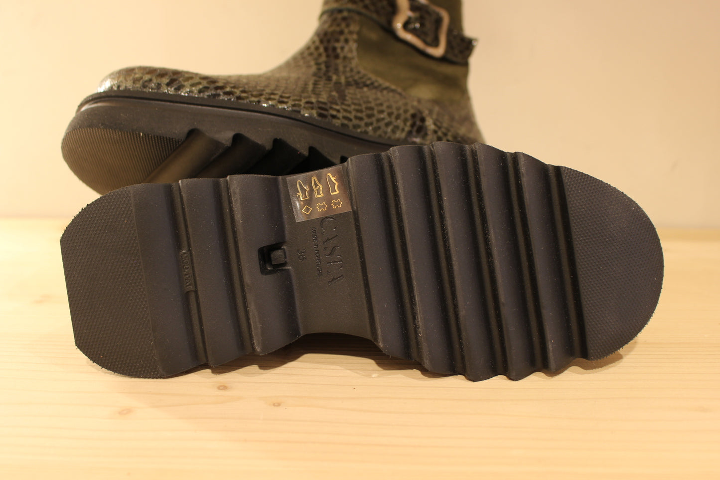 Bottines Casta en cuir imprimé python de couleur vert foncé. Finition velours sur le haut de la tige. Habillage ceinture.