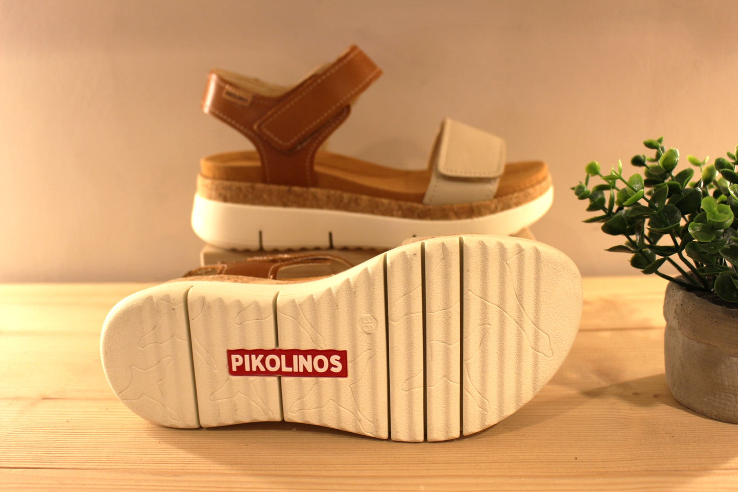 Sandales en cuir de couleur blanc cassé et camel. Serrage par deux scratchs, sur bride coup de pied et sur bride avant PIKOLINOS