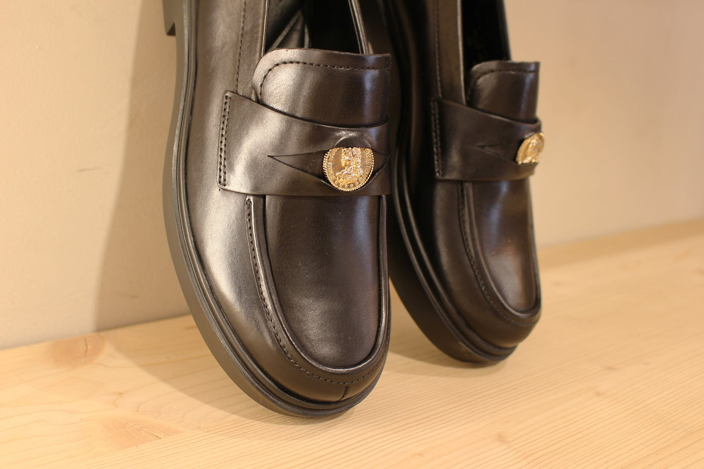 Mocassins Högl en cuir de couleur noir. Empiècement sur la barette d'une pièce dorée décorative