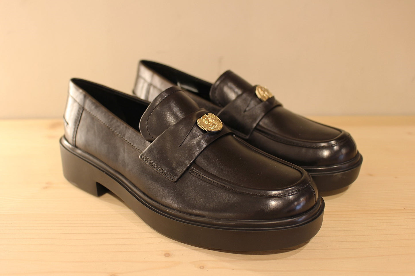 Mocassins Högl en cuir de couleur noir. Empiècement sur la barette d'une pièce dorée décorative