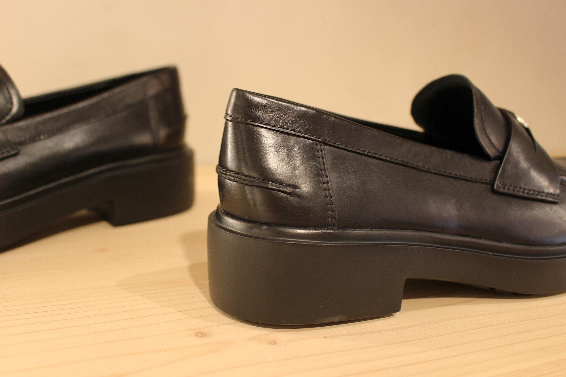 Mocassins Högl en cuir de couleur noir. Empiècement sur la barette d'une pièce dorée décorative