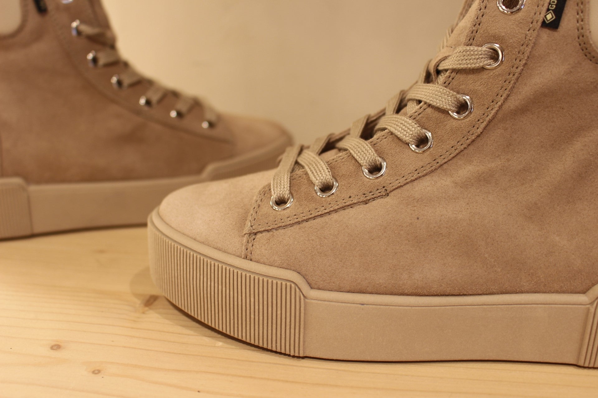 Basket Högl montante en cuir velours de couleur taupe. Cuir lisse sur le bourrelet de confort à l'arrière. Doublée gore-tex