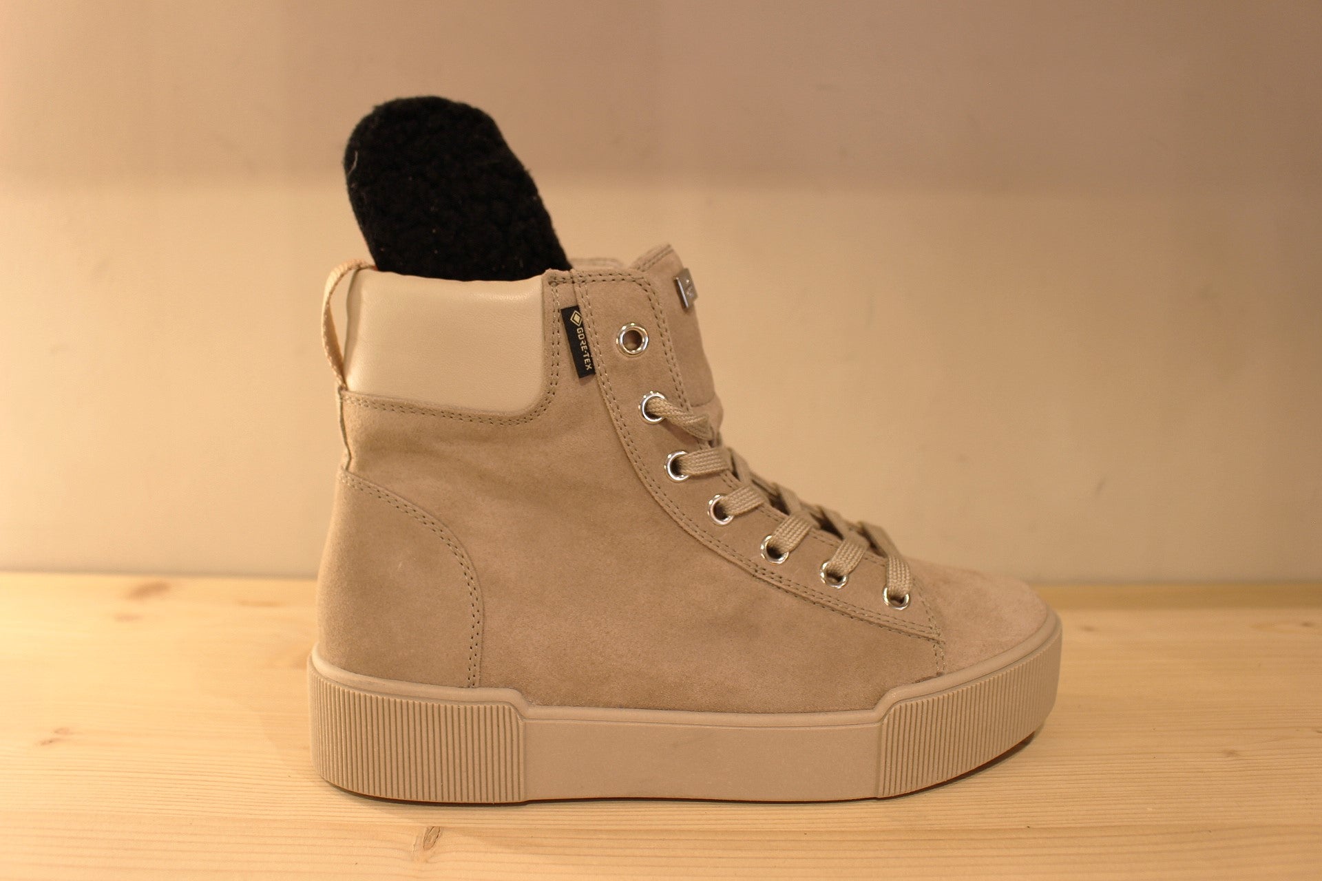 Basket Högl montante en cuir velours de couleur taupe. Cuir lisse sur le bourrelet de confort à l'arrière. Doublée gore-tex