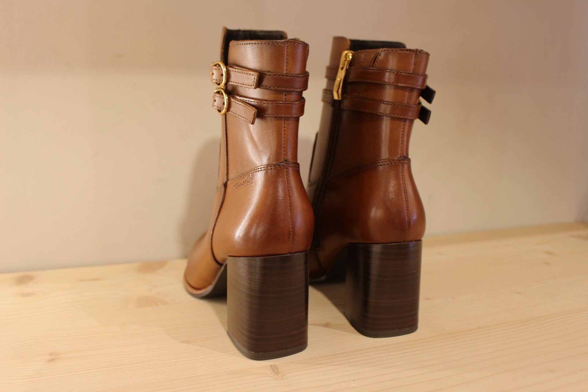 Bottines Tamaris en cuir de couleur cognac. Deux boucles déco sur le haut de la tige. Zip du côté interne