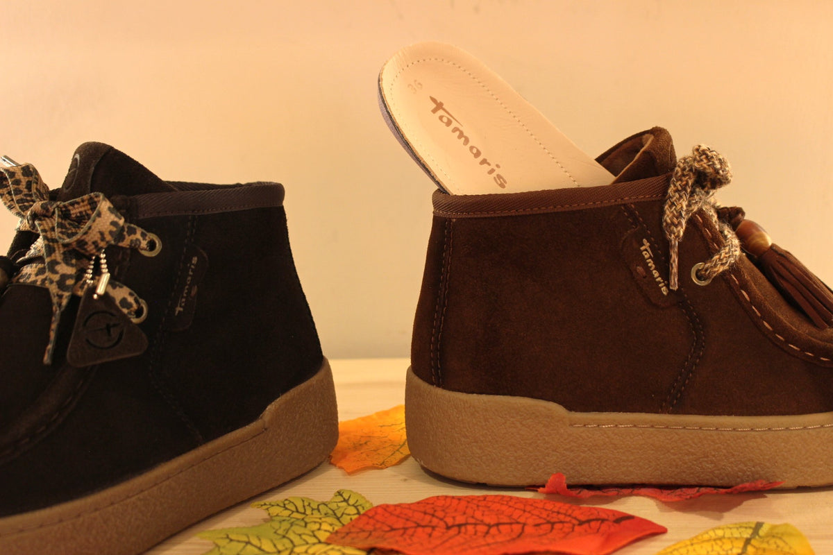 Bottines Tamaris en croûte de cuir de couleur chocolat ou de couleur muscat. Lacets coton imprimé et pampille.