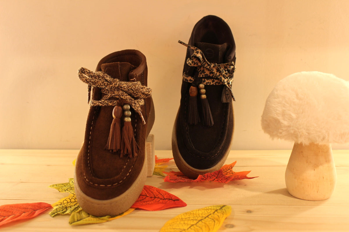 Bottines Tamaris en croûte de cuir de couleur chocolat ou de couleur muscat. Lacets coton imprimé et pampille.