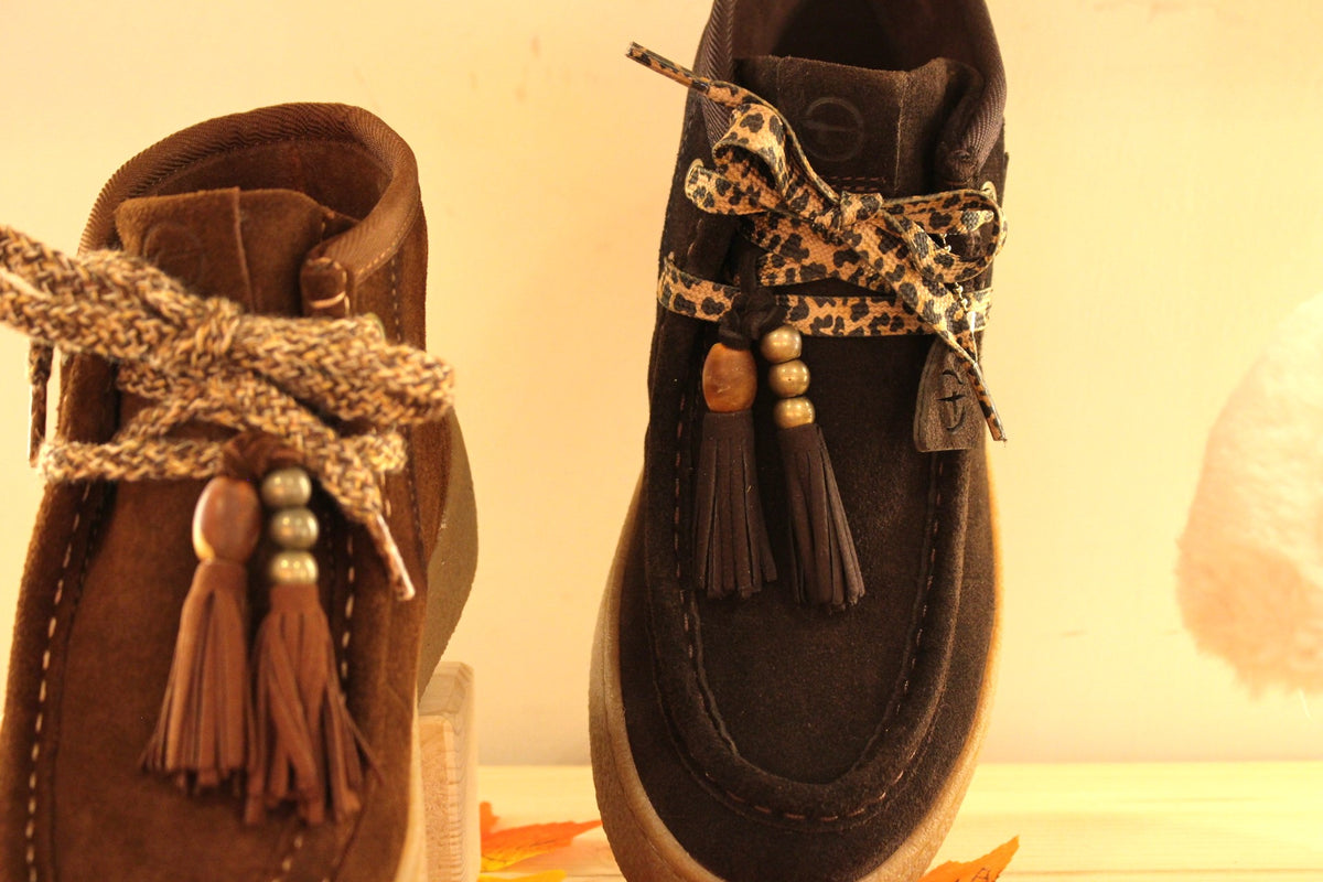 Bottines Tamaris en croûte de cuir de couleur chocolat ou de couleur muscat. Lacets coton imprimé et pampille.