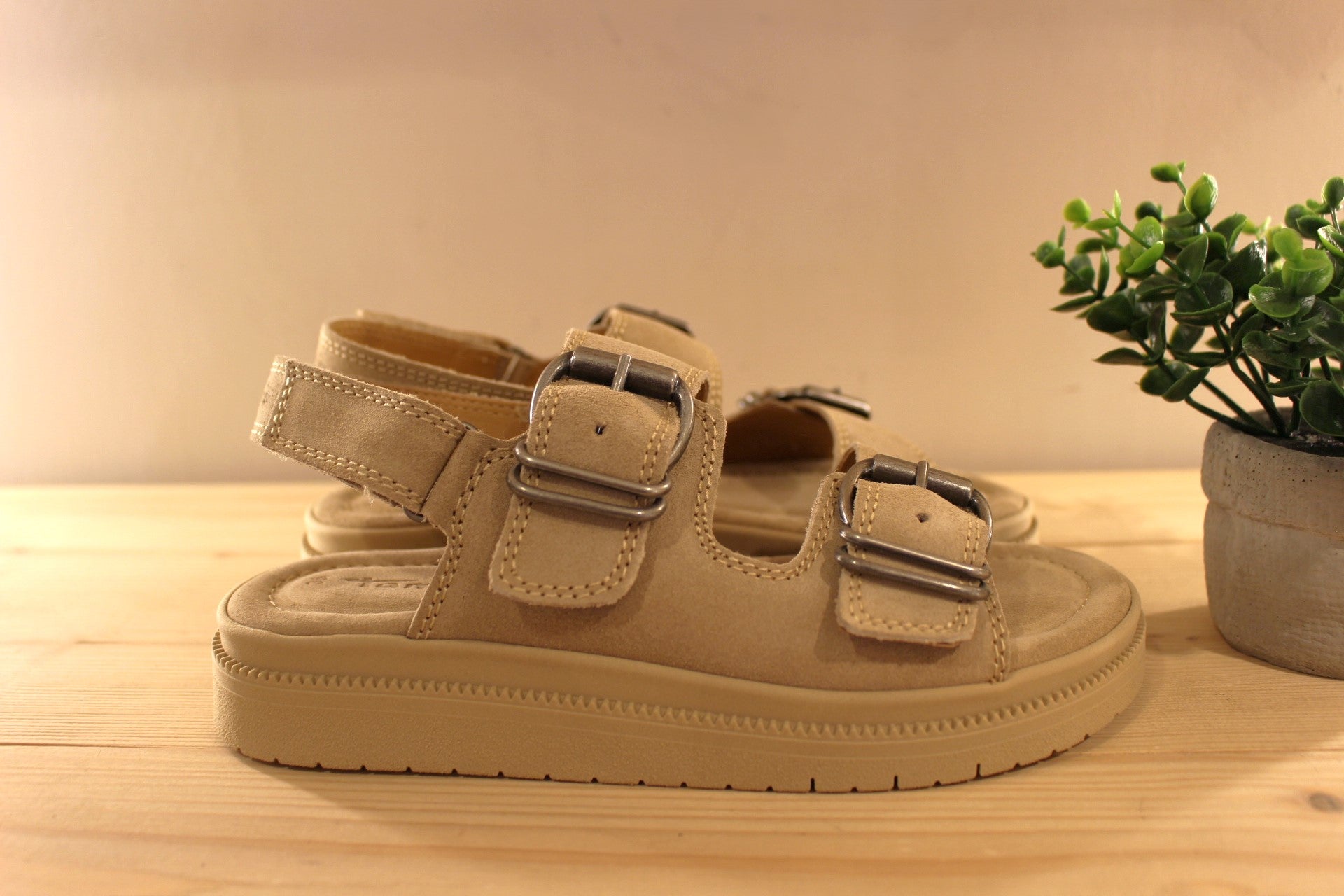 Sandales en croûte de cuir de couleur beige. Serrage par scratch sur bride arrière. Réglage boucle sur bride coup de pied et avant. TAMARIS