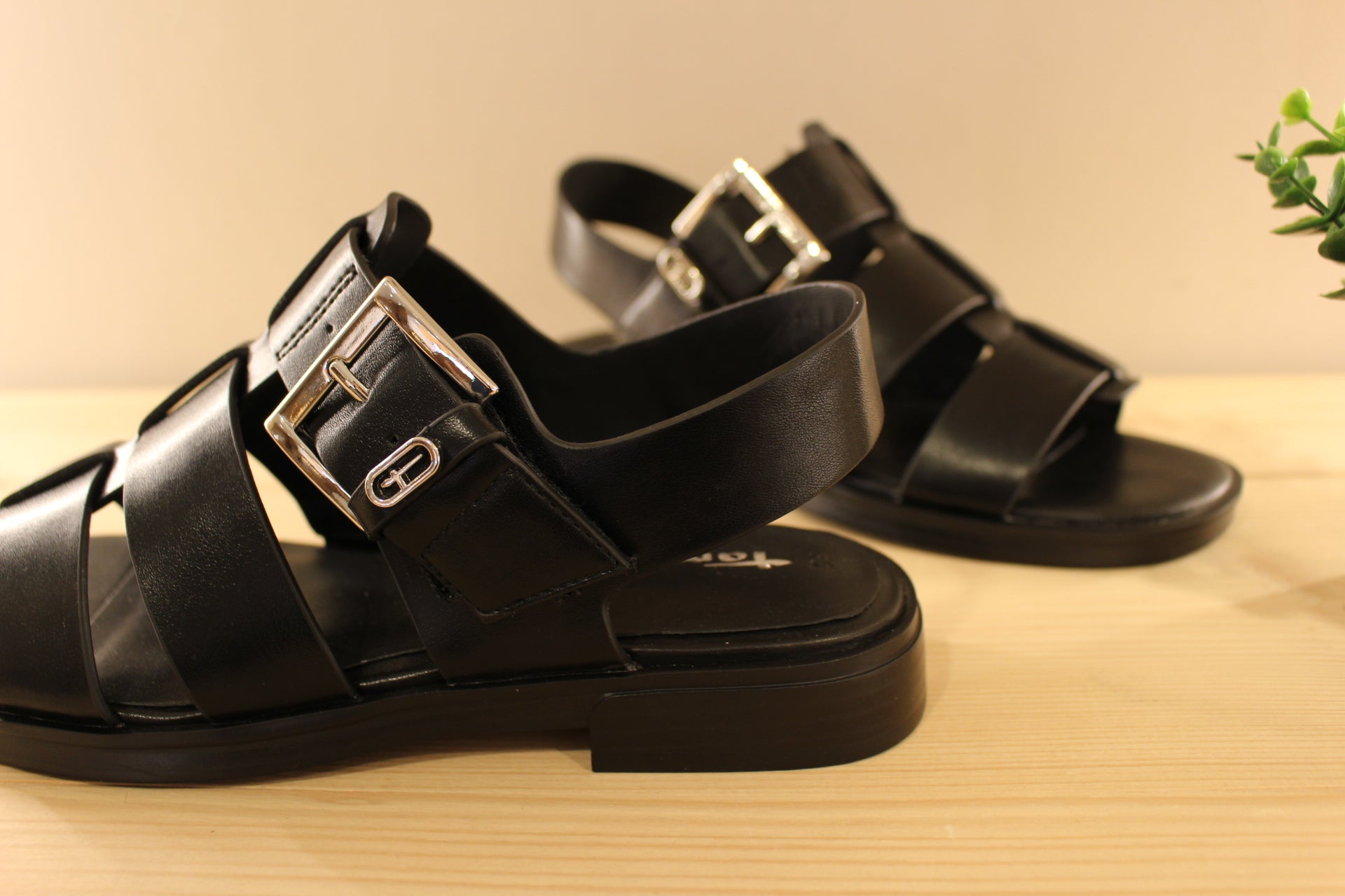 Sandales en cuir de couleur noir. Serrage par scratch sur bride coup de pied. Boucle décorative, et réglable. TAMARIS