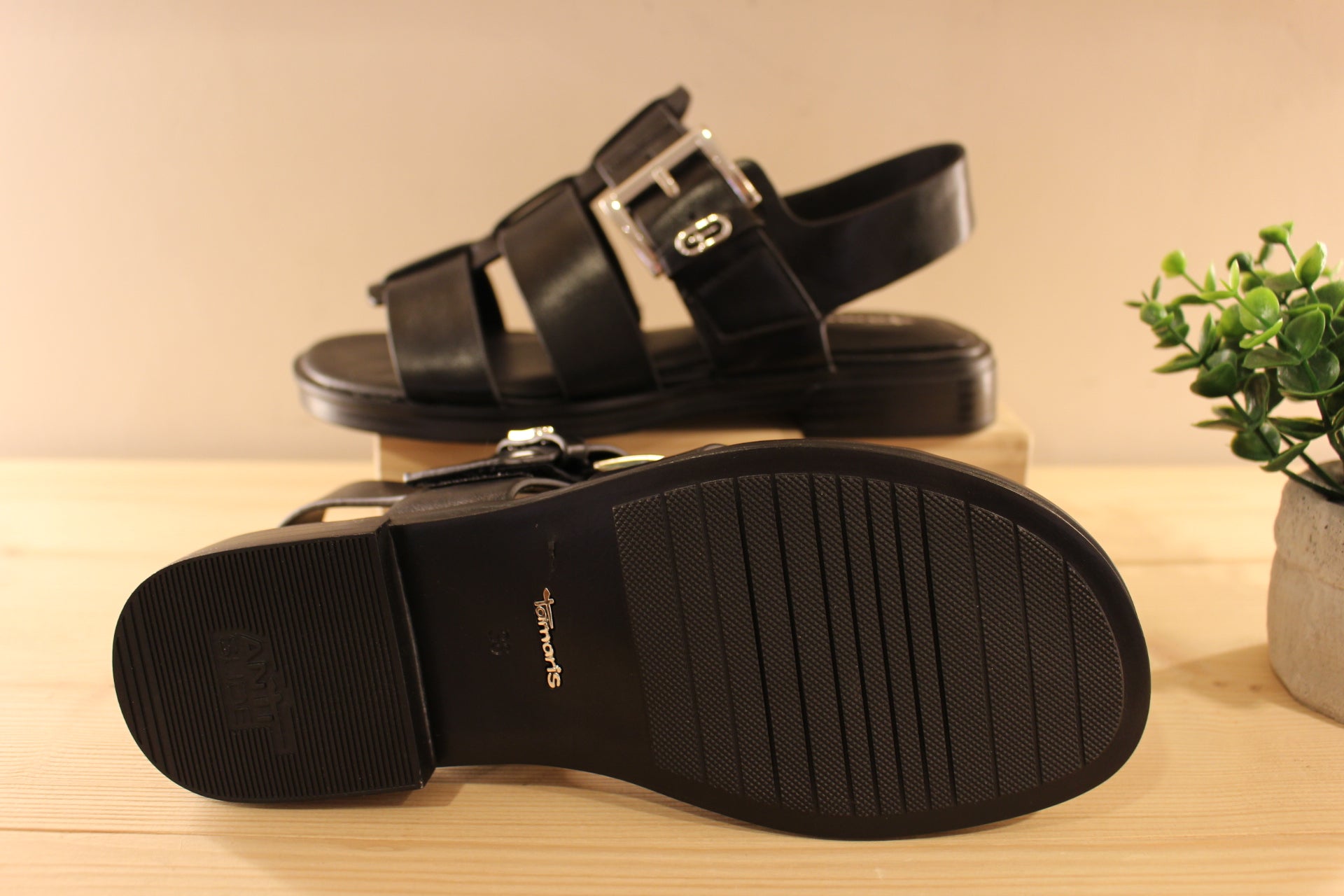 Sandales en cuir de couleur noir. Serrage par scratch sur bride coup de pied. Boucle décorative, et réglable. TAMARIS