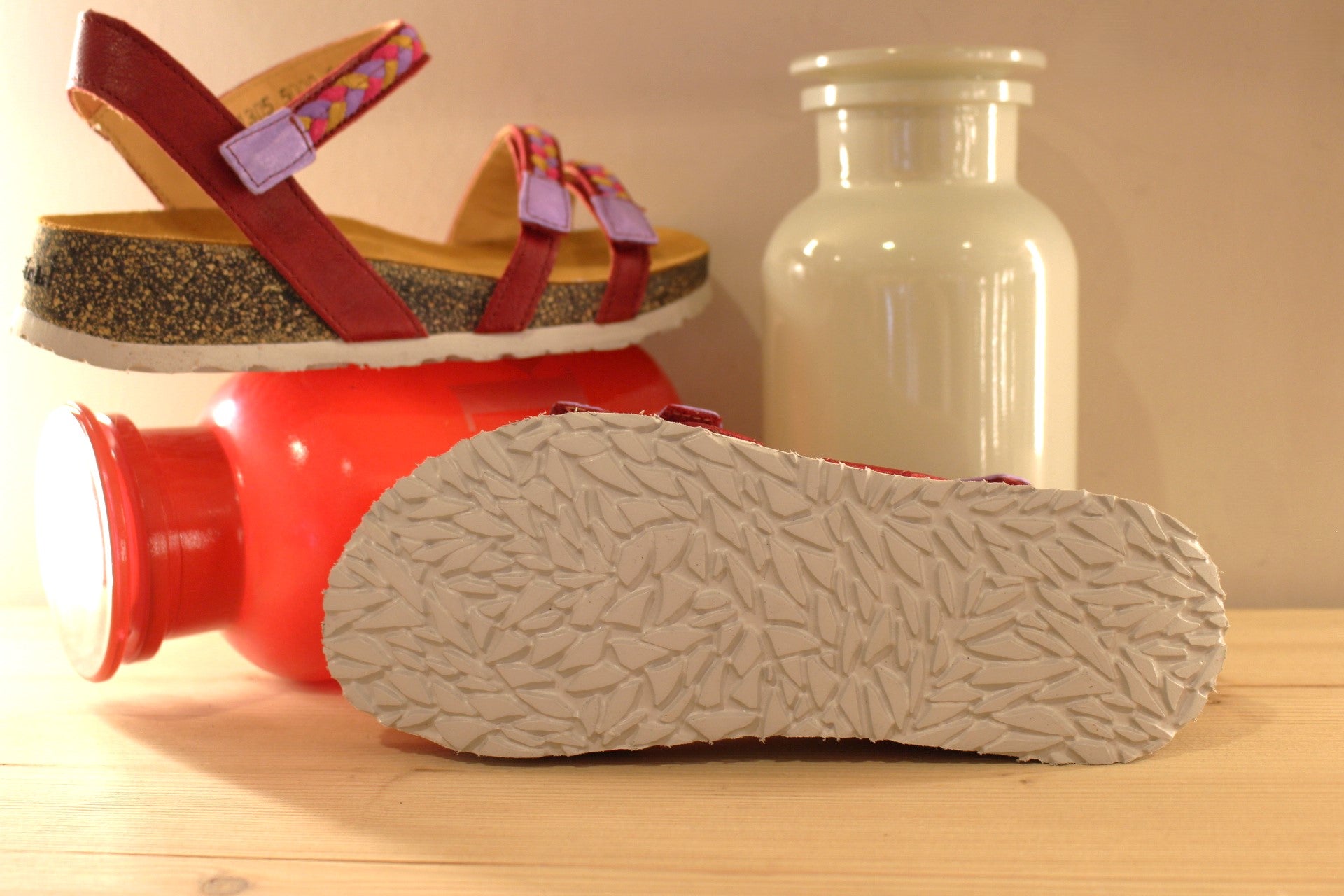 Sandales THINK en cuir de couleur rouge fraise. Habillage des brides en tressé de cuirs colorés parme, rouge et jaune. Serrage par trois scratchs. Chaussures extra légères. Semelle interne anatomique