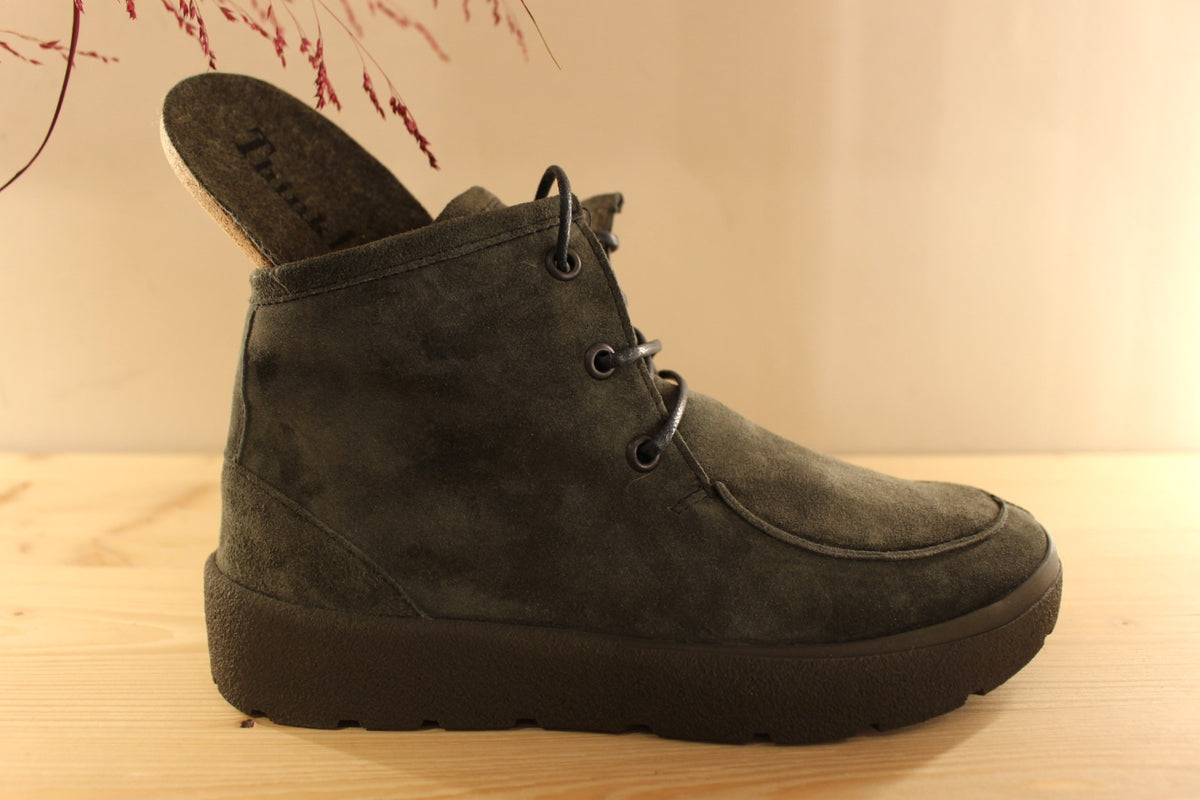 Bottines THINK en cuir velours de couleur vert. Serrage lacets coton bleus avec les embouts rouges. Zip du côté interne