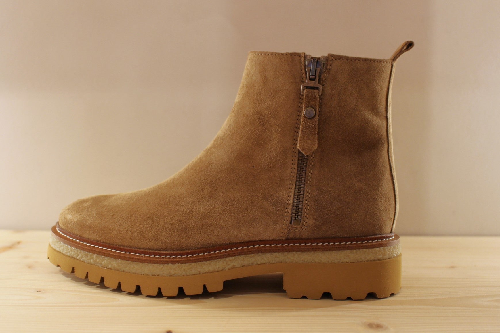 Bottines en croûte de cuir de couleur marron taupe. Serrage zip coté interne ton sur ton. Zip du côté externe décoratif.