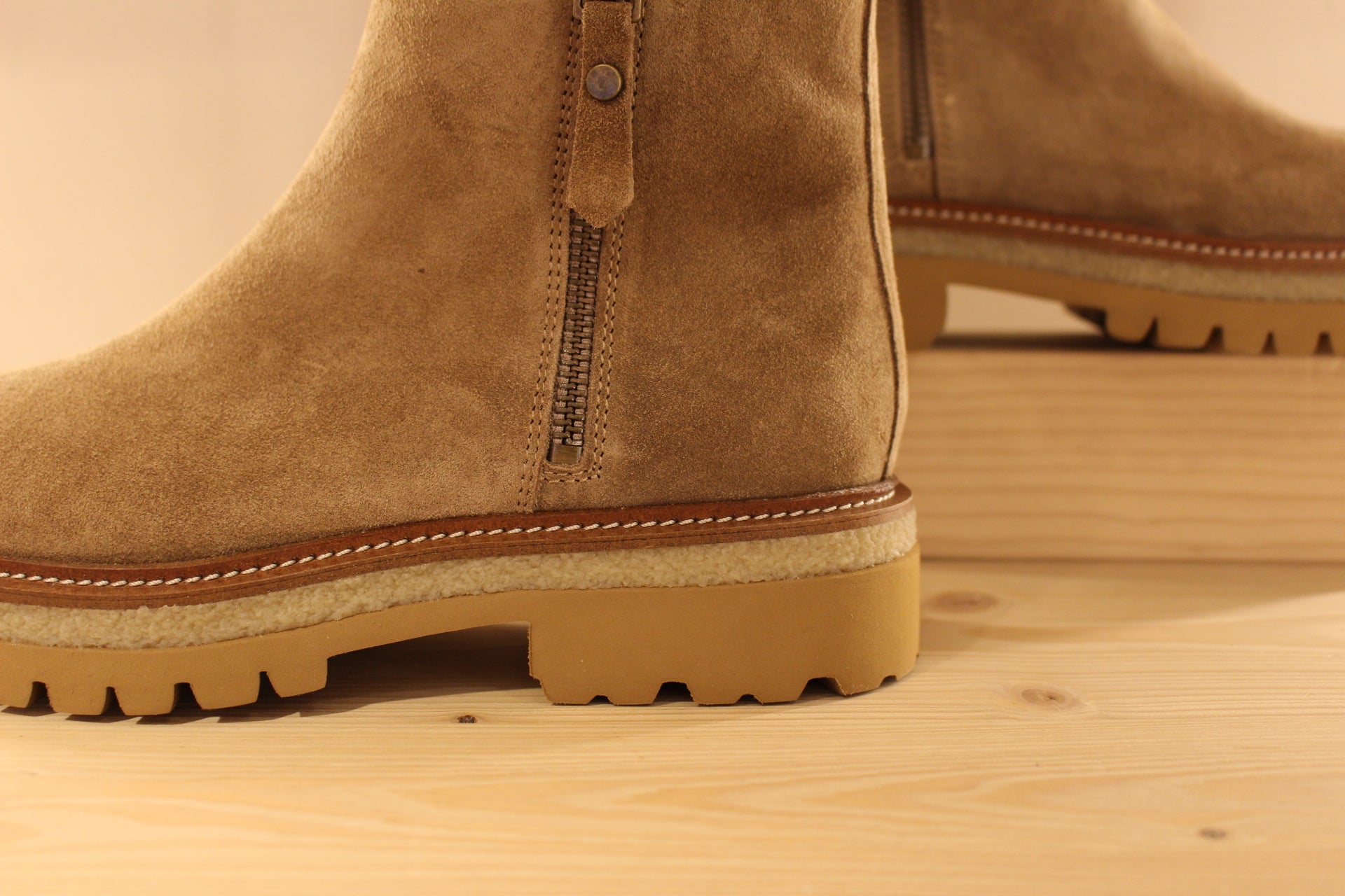 Bottines en croûte de cuir de couleur marron taupe. Serrage zip coté interne ton sur ton. Zip du côté externe décoratif.