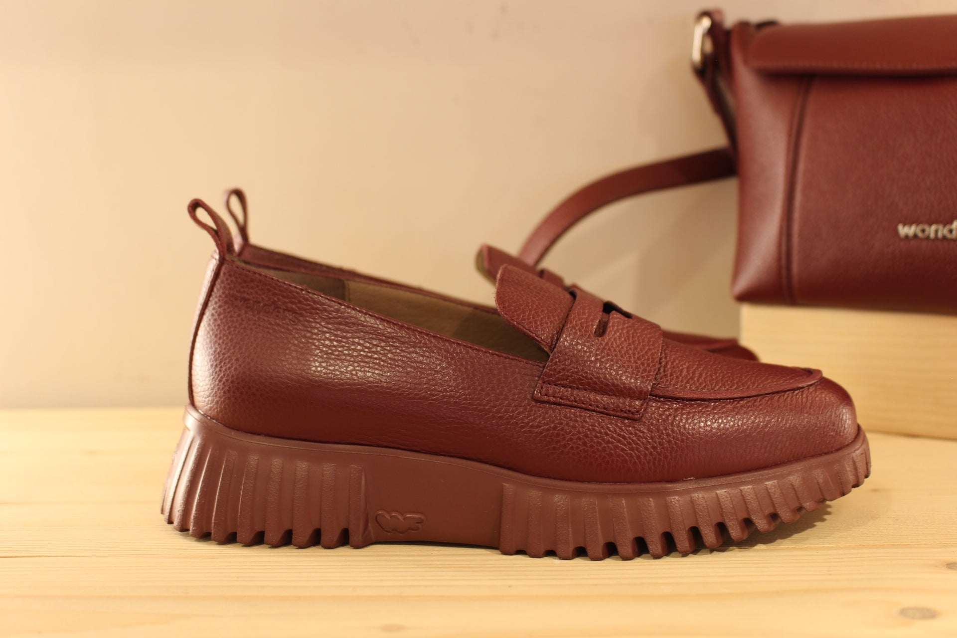 Mocassins WONDERS en cuir grainé de couleur bordeaux. Barette décorative ton sur ton. Chaussures doublées cuir et semelle interne amovible