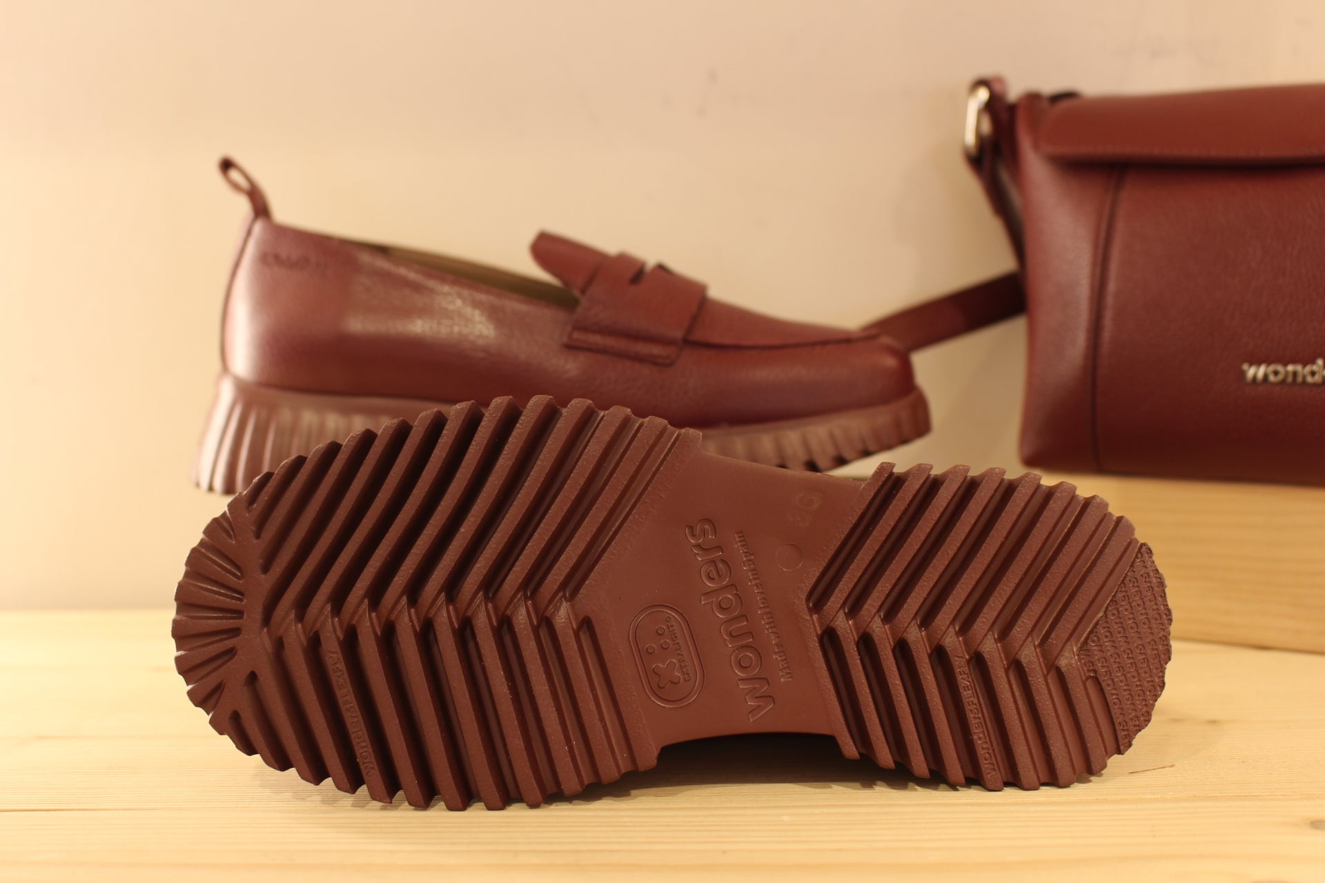 Mocassins WONDERS en cuir grainé de couleur bordeaux. Barette décorative ton sur ton. Chaussures doublées cuir et semelle interne amovible