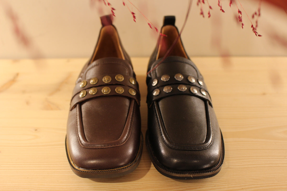 Mocassins Mamzelle en cuir de couleur noir ou moka. Habillage clous étoilés sur la barette coup de pied