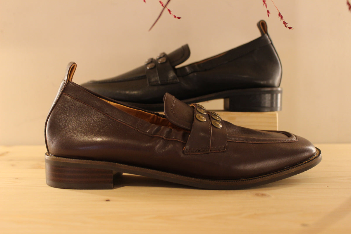 Mocassins Mamzelle en cuir de couleur noir ou moka. Habillage clous étoilés sur la barette coup de pied