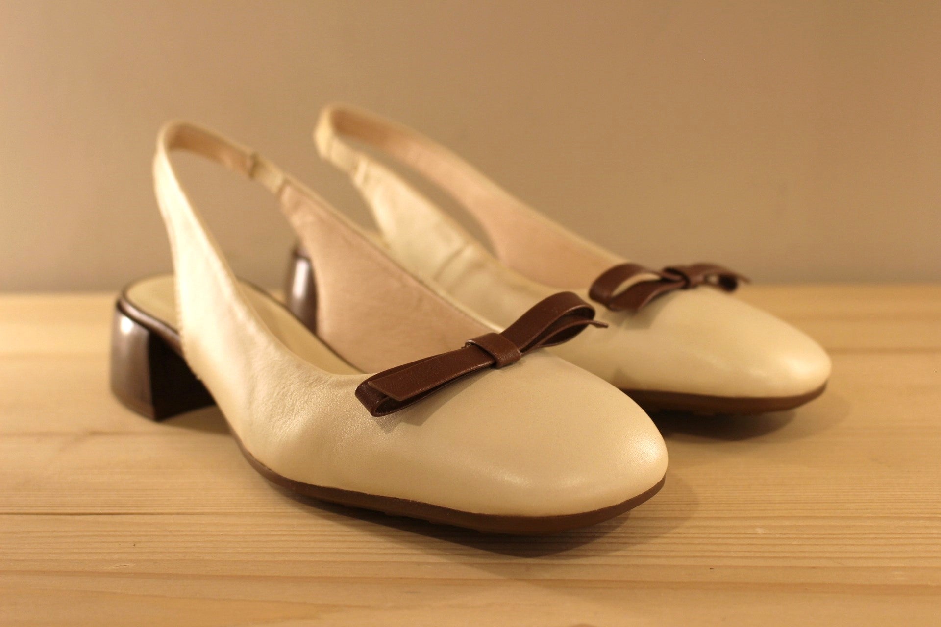 Trotteur HISPANITAS en cuir de couleur butter (créme) avec un noeud élégant en cuir marron. Arrière ouvert.