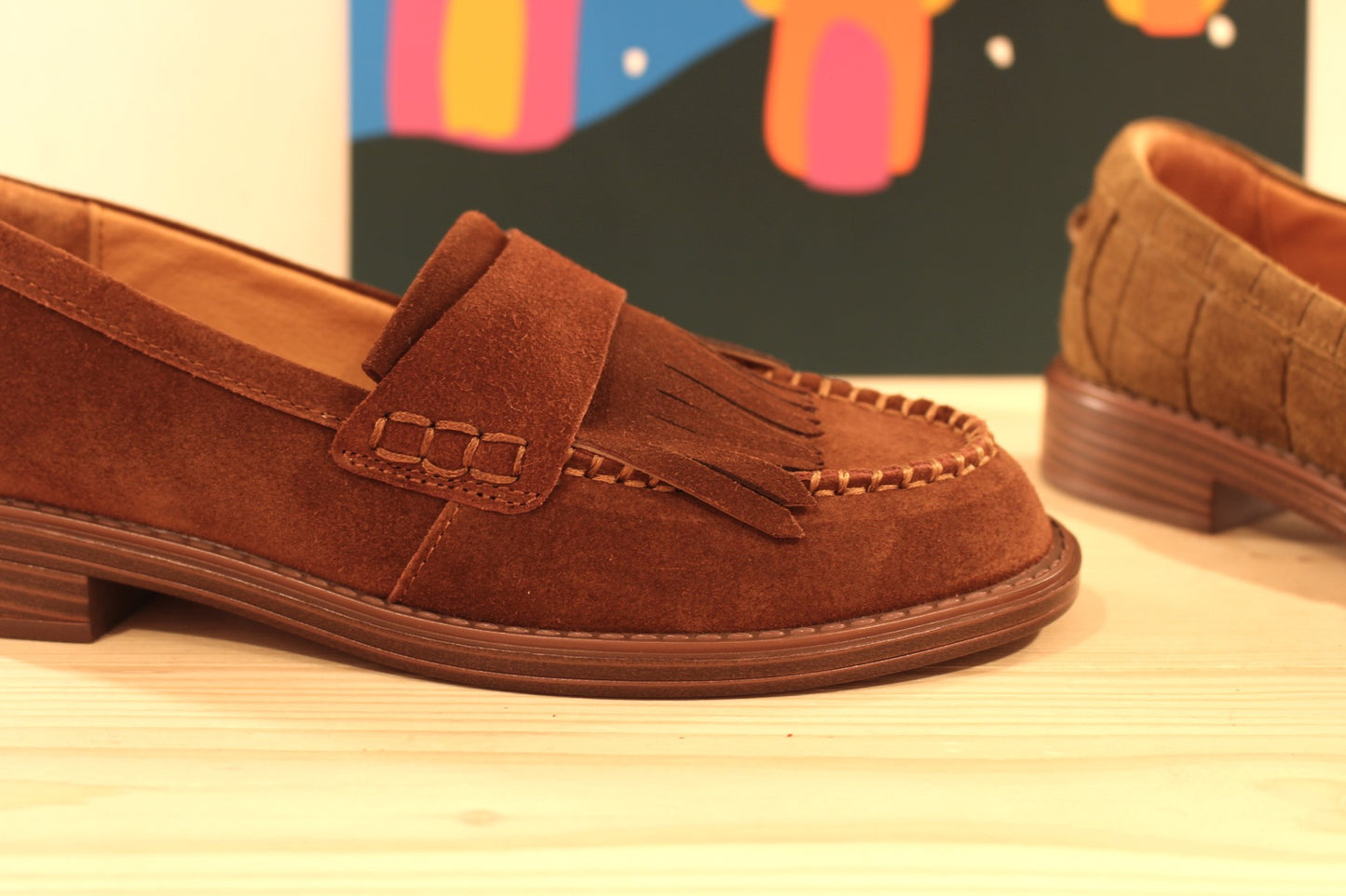 Mocassins Mamzelle en cuir velours de couleur vison (kaki) imprimé croco ou de couleur chocolat. Retour de cuir sur patte frangée ton sur ton sur le coup de pied.