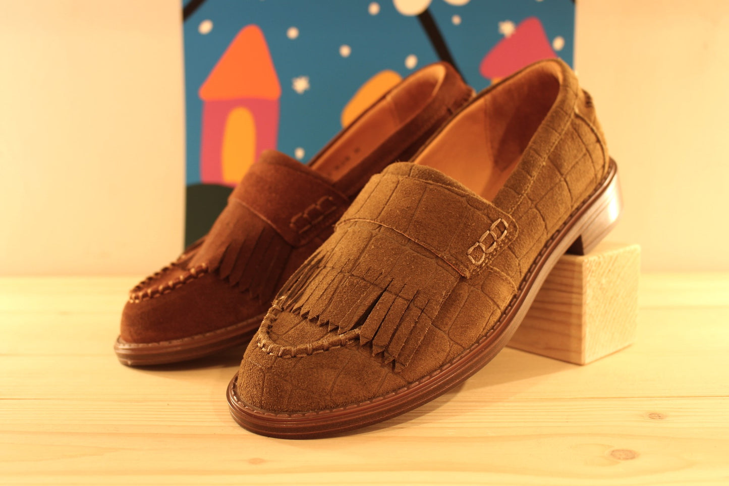 Mocassins Mamzelle en cuir velours de couleur vison (kaki) imprimé croco ou de couleur chocolat. Retour de cuir sur patte frangée ton sur ton sur le coup de pied.
