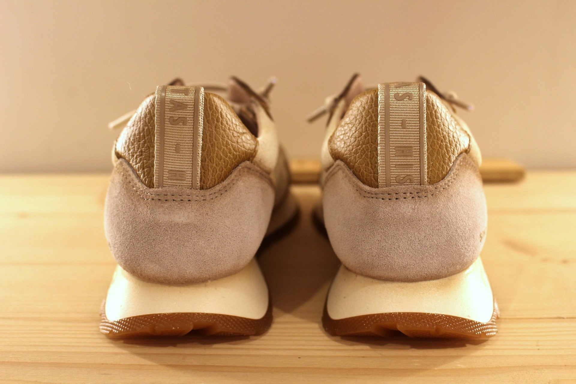 Basket en cuir de couleur crème et métallisé étain. Languette en laine bouclette ton sur ton. Lacets élastiqués beige.