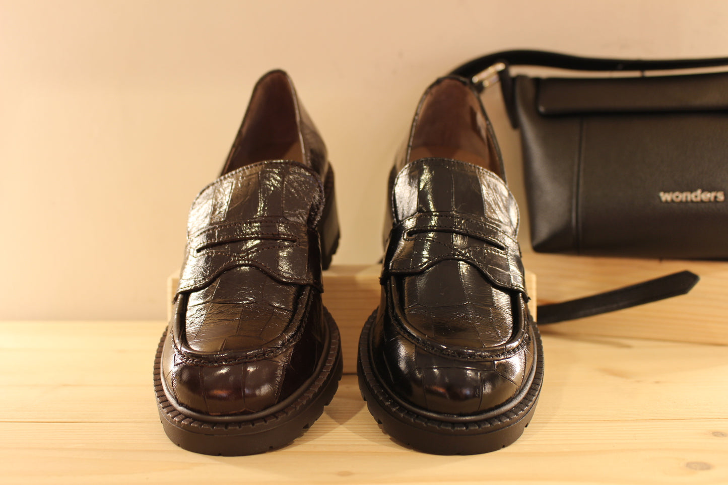 Mocassins WONDERS en cuir vernis aspect croco de couleur noir ou de couleur chocolat. Barette coup de pied ton sur ton.