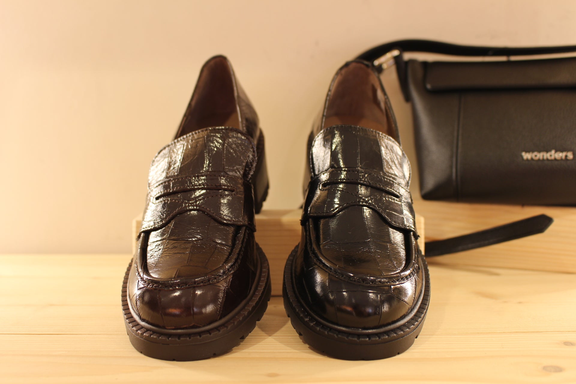 Mocassins WONDERS en cuir vernis aspect croco de couleur noir ou de couleur chocolat. Barette coup de pied ton sur ton.