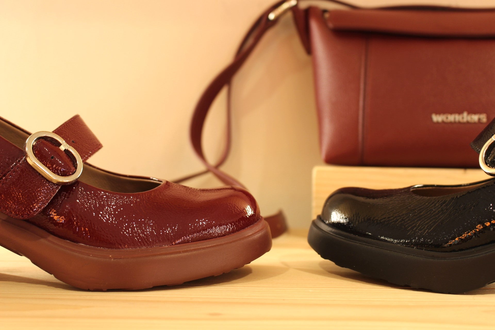 Babies WONDERS en cuir vernis de couleur noire ou de couleur bordeaux. Serrage par boucle sur bride coup de pied.