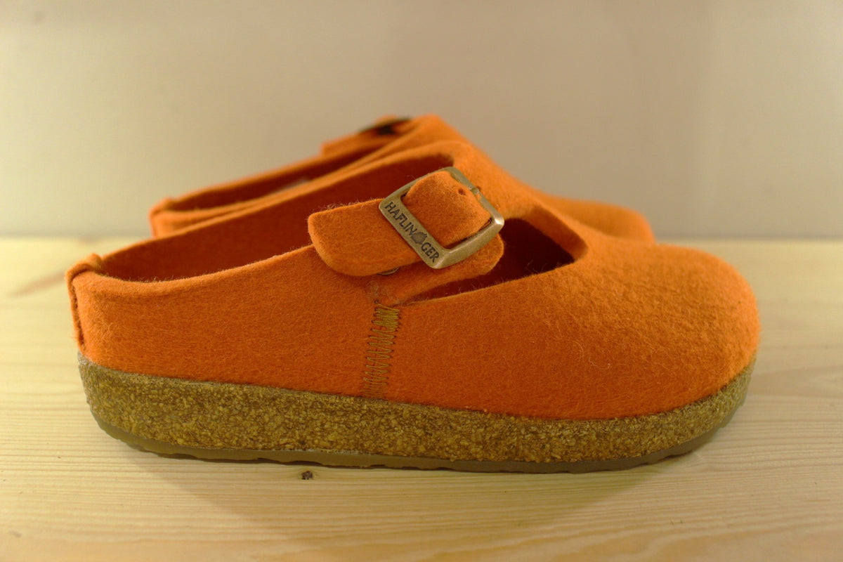 Chaussons HAFLINGER coupe sabot en pur laine de couleur orange. Serrage par boucle sur bride coup de pied