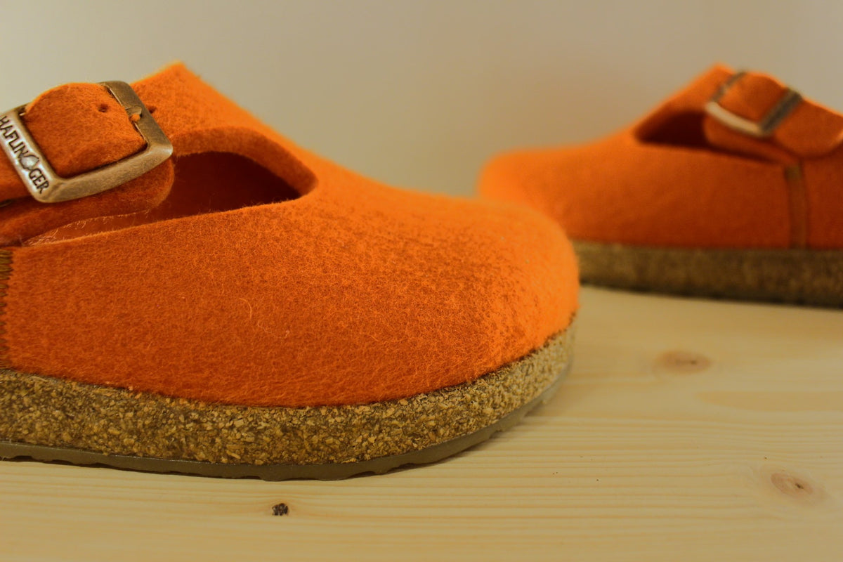 Chaussons HAFLINGER coupe sabot en pur laine de couleur orange. Serrage par boucle sur bride coup de pied