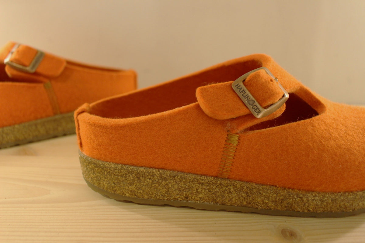 Chaussons HAFLINGER coupe sabot en pur laine de couleur orange. Serrage par boucle sur bride coup de pied