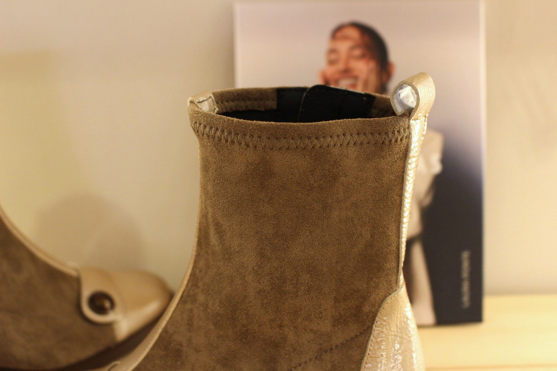 Bottine en cuir lisse de couleur crème avec une patine légèrement bruni. Bride vernis crème et bouton étain sur le coup de pied. Tige en velours taupe avec arrière vernis. 
