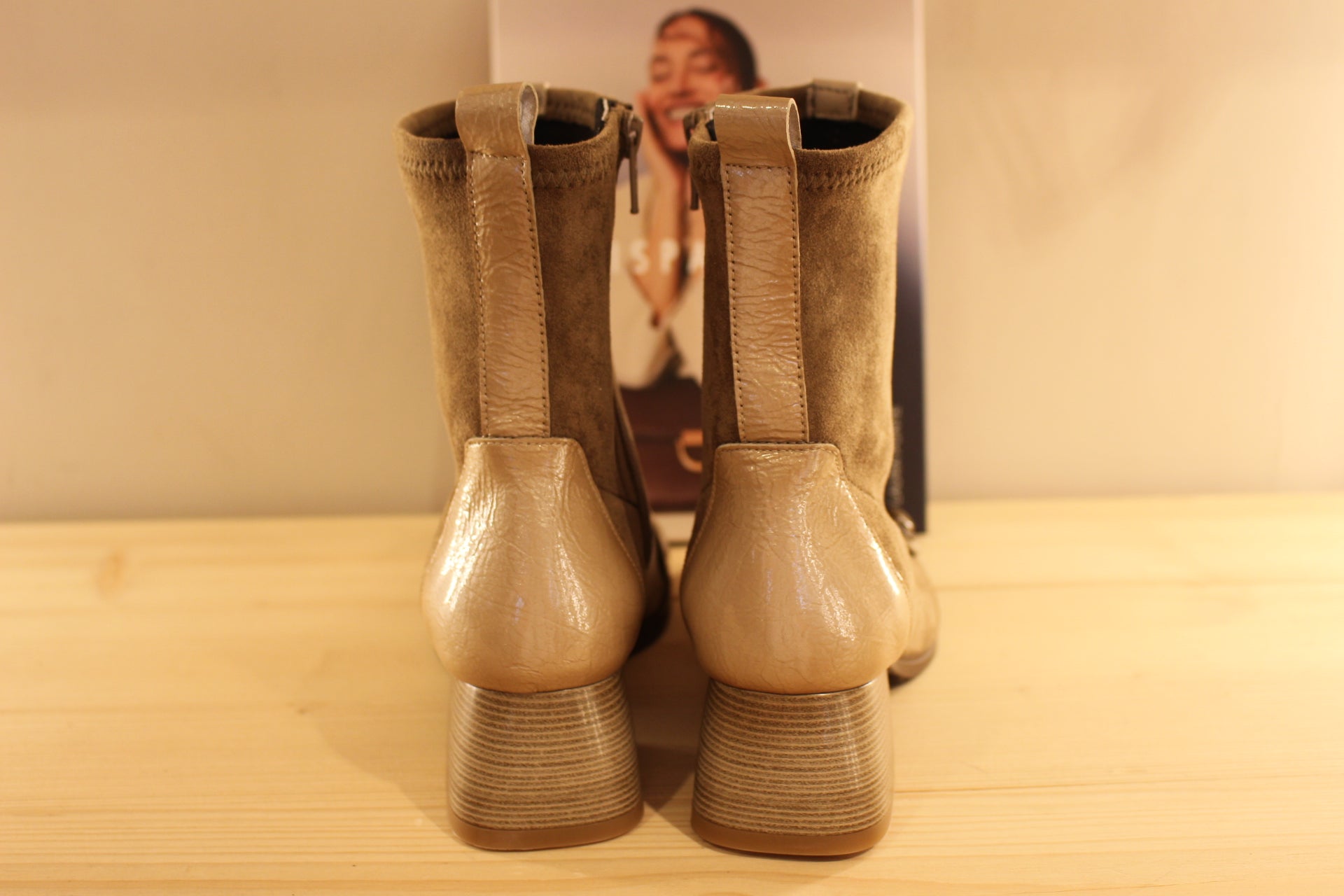 Bottine en cuir lisse de couleur crème avec une patine légèrement bruni. Bride vernis crème et bouton étain sur le coup de pied. Tige en velours taupe avec arrière vernis. 