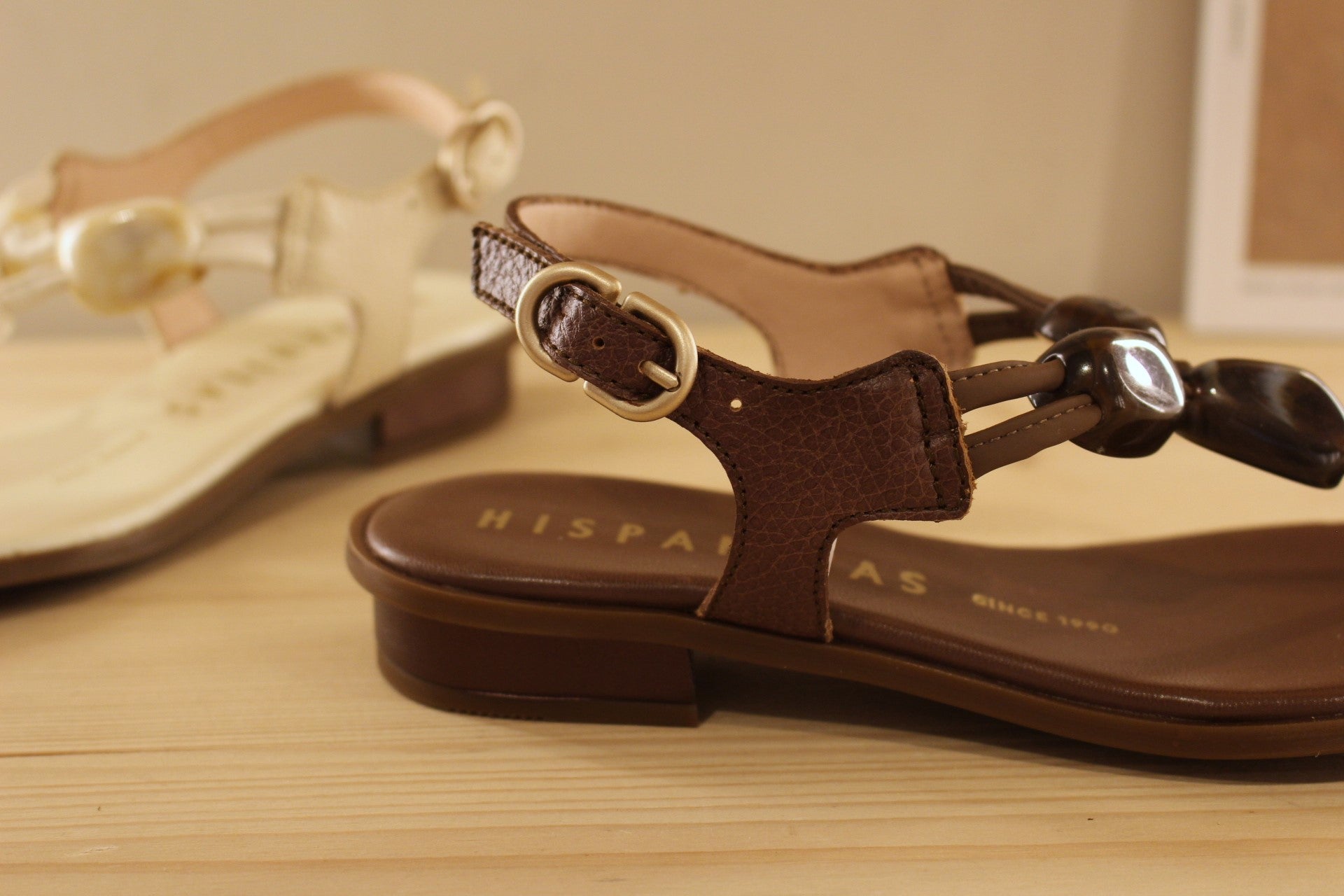 Entre-doigt HISPANITAS en cuir de couleur butter (créme) ou de couleur noisette. De jolies pierres ton sur ton habillent le salomé