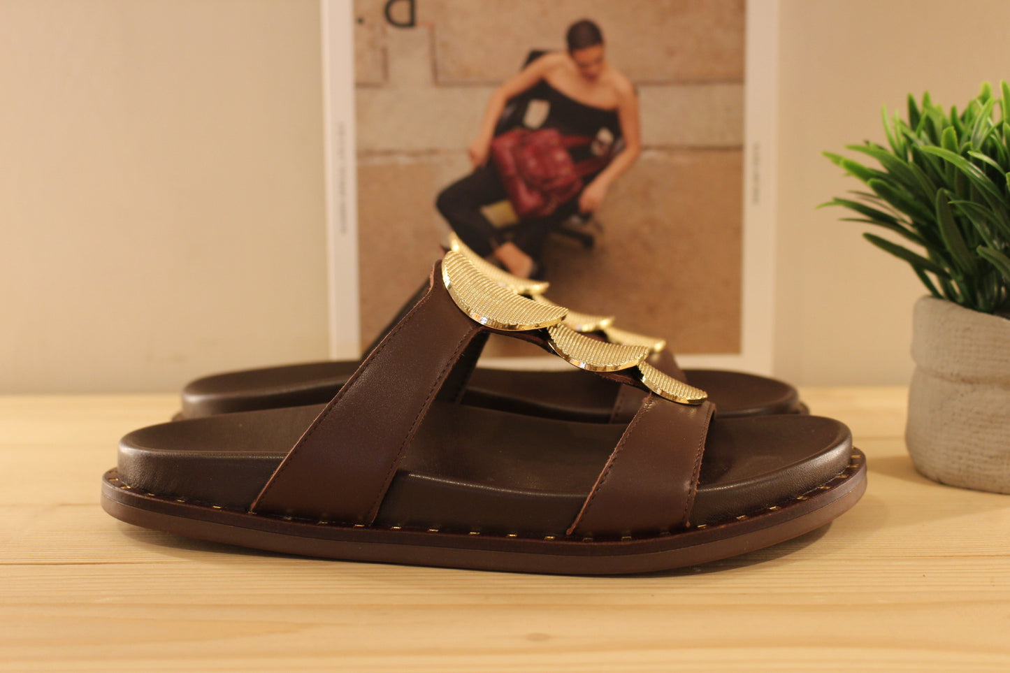 Mule ALPE en cuir de couleur chocolat. Habillage médaillon métallisé platine imprimé sur la bride salomé.